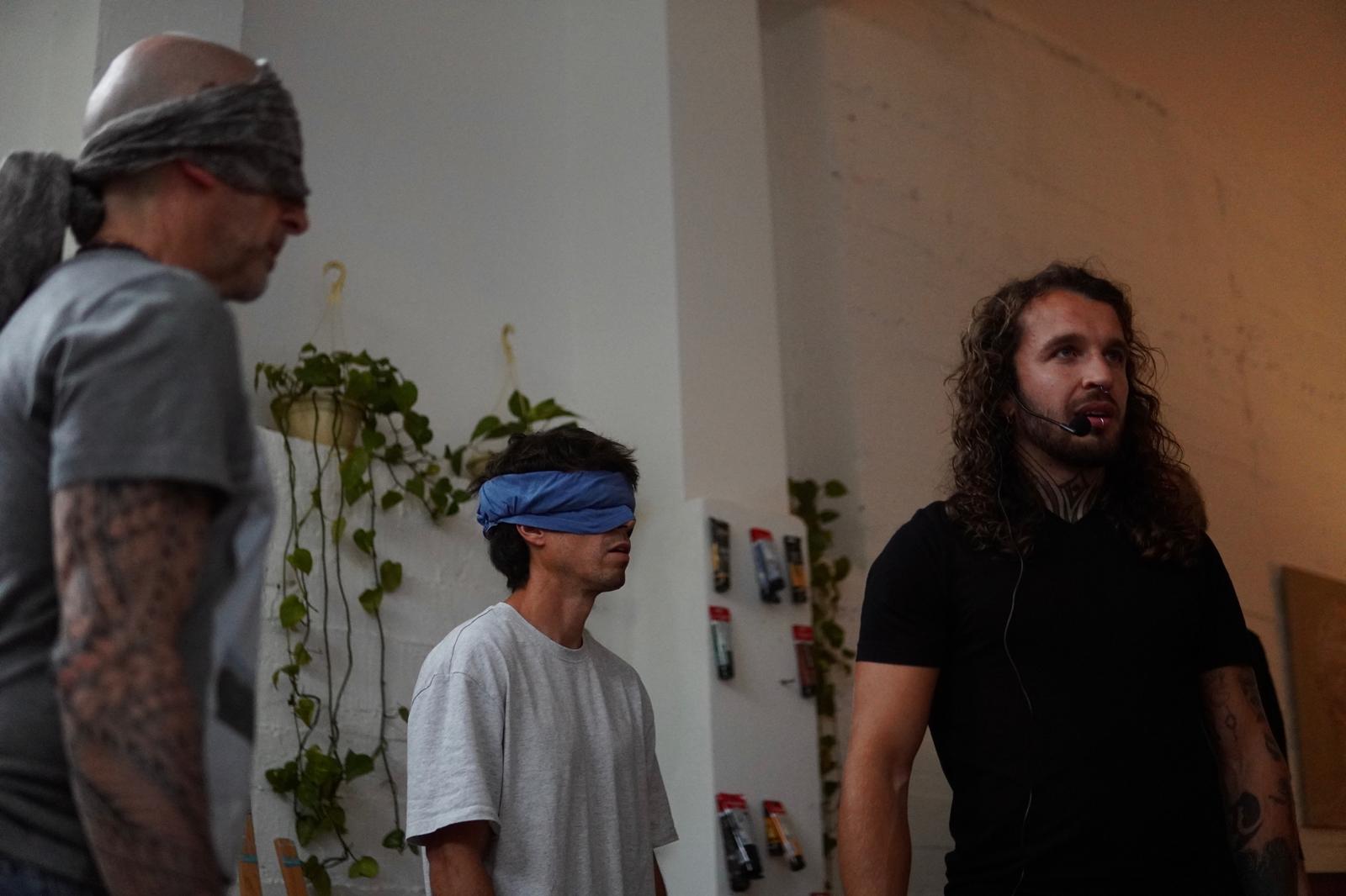 Esaú guiding participants through a blindfolded embodiment practice